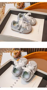 Détail de baskets argentées pour filles avec d'élégants lacets en dentelle blanche