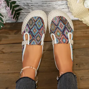 Detailansicht von gewebten Canvas-Slippern im Ethno-Stil mit Boho-Accessoires am Fuß