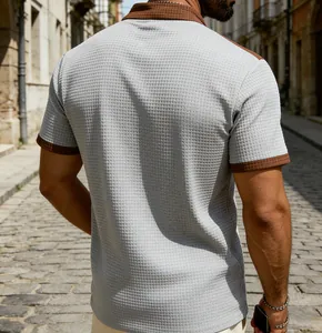 Back view of a grey waffle textured men's short sleeve polo with brown checkered trim.