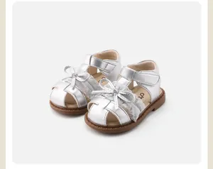 Detailed close-up view of silver toddler girl sandals with lace trim and elegant bow accent