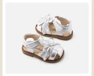 Detailed top view of silver baby girl sandals featuring lace trim and a cute bow