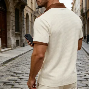 Detailed view of the waffle texture on this cream and brown men's half-zip polo shirt