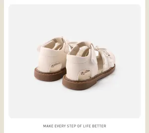 Rear view of cream lace baby girl sandals featuring soft non-slip brown rubber soles