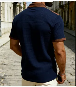 Back view of navy blue waffle knit polo shirt with contrast brown collar and cuffs