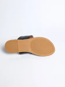 Detailed view of the tan anti-slip sole on a black crocodile-texture slide sandal