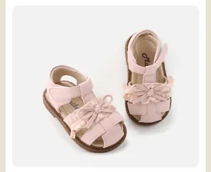 Overhead detail view of pink baby girl sandals with lace bow and soft sole