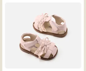 Close-up of pink baby girl sandals with sweet lace bow detailing and soft hollow soles