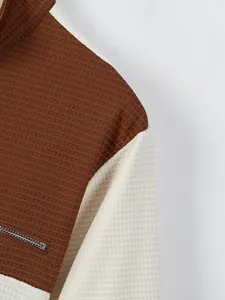 Close-up of waffle knit texture on men's color block half-zip shirt with zipper pocket