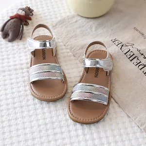 Close-up of girls' silver metallic sandals with colorful textured gradient straps