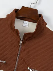 Detail of color-block casual top showing grid texture and stand collar with half zipper.