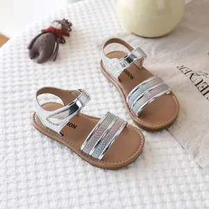 Close-up of silver glittery girls' sandals with rainbow stripes and soft soles.