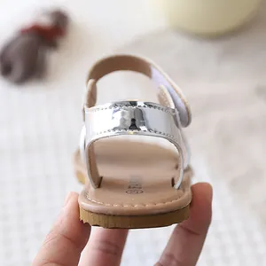 Detail view of a silver metallic girls' flat roman sandal showing heel and soft sole