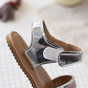 Close-up of silver metallic girl's sandal with adjustable hook-and-loop strap