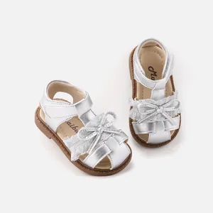 Silver baby girl sandals with lace trim and sweet bow details, soft sole shoes.