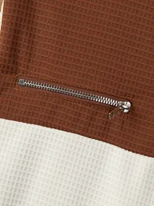 Close-up of textured waffle fabric and metal zipper pocket on this men's casual top
