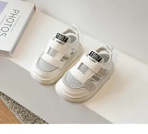 Gros plan de sandales de sport en maille blanche respirante pour bébés avec velcro.