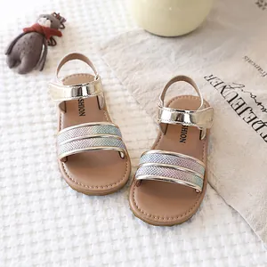 Detail view of girls' gold sandals with rainbow glitter straps and soft soles.