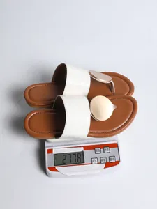 Detailed view of white crocodile texture sandals on a digital scale showing weight of 277.8g