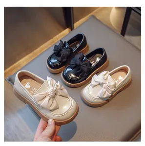 Vue détaillée de mocassins pour filles de style britannique avec nœuds noirs et beiges