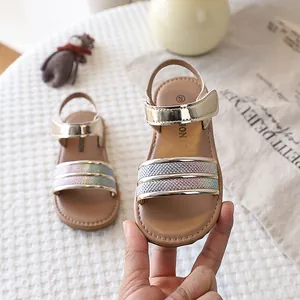 Detailed close-up of toddler girls' gold metallic sandals with rainbow glitter straps