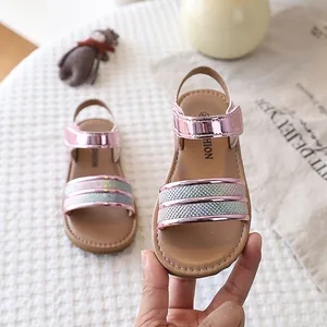 Close-up of pink girls sandals with iridescent glitter straps and soft sole