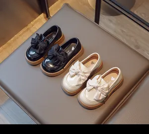 Vue détaillée des mocassins pour filles en noir et blanc avec gros nœuds