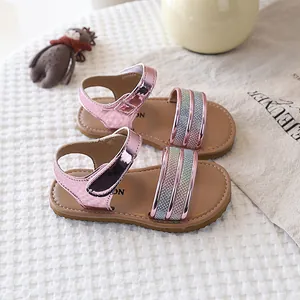 Detailed shot of pink sparkly sandals for girls with soft soles and velcro straps.