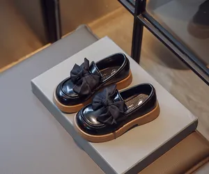 Vue détaillée de mocassins noirs style anglais pour filles avec grand nœud
