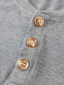 Détail en gros plan d'un tricot gris avec trois boutons marron style écaille