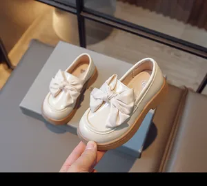 Vue détaillée de mocassins crème pour filles avec grand nœud et semelle épaisse