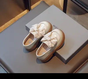 Vue détaillée de mocassins en cuir crème pour filles de style anglais avec grands nœuds