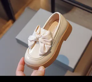 Vue détaillée des mocassins crème pour filles de style britannique avec nœud élégant