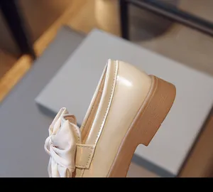 Vue détaillée d'un mocassin en cuir verni beige pour filles avec un grand nœud en satin chic