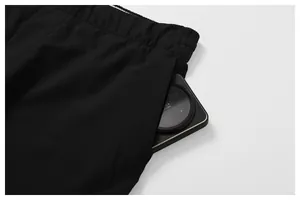 Gros plan sur la poche latérale profonde du pantalon de sport noir à séchage rapide