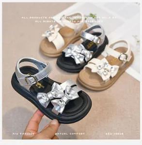 Detailed view of girls' sandals with sparkling rhinestone bow-knot and velcro strap