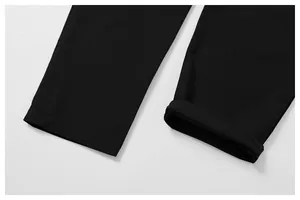Vue rapprochée des ourlets de jambes d'un pantalon de sport noir pour extérieur.