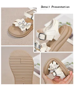 Detail view of girls' rhinestone bow sandals with flexible non-slip soles.