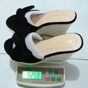 Detalle de la medición del peso de las sandalias con plataforma y lazo negro, 525,8g