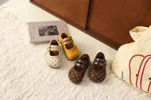 Detail van schattige polka dot Mary Jane schoenen voor meisjes in beige geel bruin