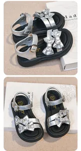 Elegant silver girls' sandals featuring rhinestone bows and secure ankle straps.