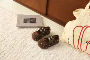 Detailweergave van bruine Mary Jane-schoenen voor meisjes met blauwe stippen en gespen