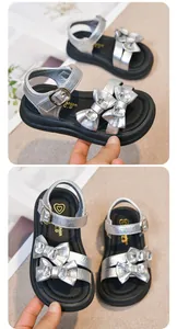 Detailed close-up view of silver girl sandals featuring sparkling rhinestone bows