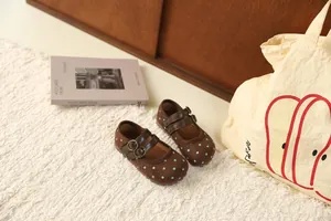 Detailweergave van bruine Mary Jane-schoenen met stippen en dubbele gespen voor meisjes.