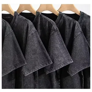 Close-up detail of vintage acid-washed black cotton t-shirts on wooden hangers