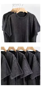 Close-up of vintage acid-washed texture on heavy 240G cotton t-shirts on wooden hangers.