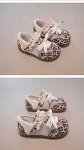 Detail von Baby-Netzschuhen mit Leopardenmuster für Mädchen mit Spitzenbesatz.