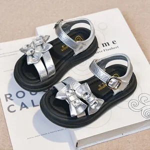Elegant silver girls' sandals featuring sparkling rhinestones and bow design for kids