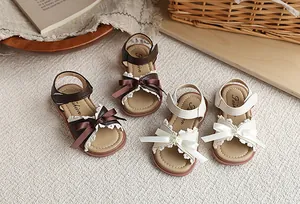 Vue détaillée de sandales stylées pour enfants avec nœuds en marron et crème.