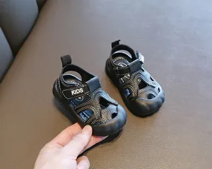 Gros plan de sandales noires pour tout-petits avec surpiqûres blanches et semelle souple