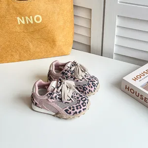 Dettaglio ravvicinato di scarpe sportive leopardate rosa per bambini con design in mesh.